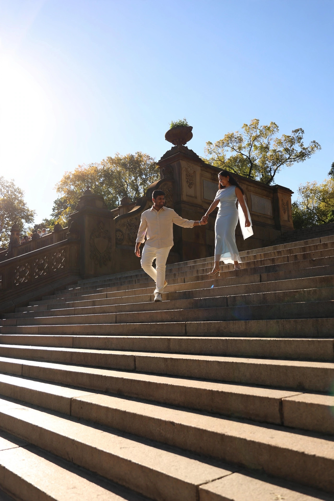 Karthik leading Dakshinya by the hand down the grand stone steps of Bethesda Terrace